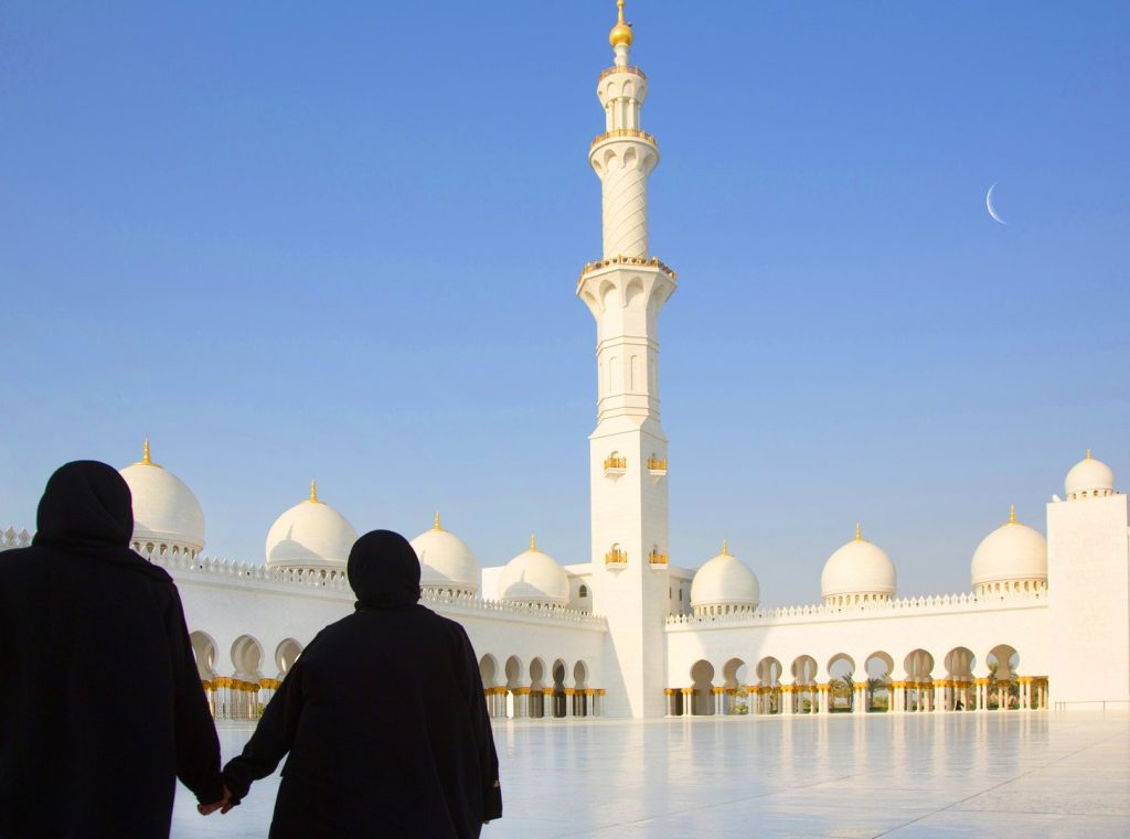 two-women-in-a-mosque-courtyard-of-colonnades